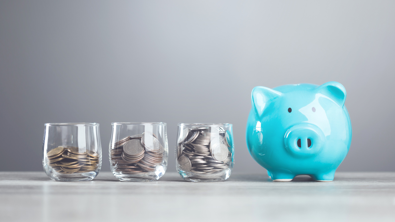 A man dropping coins into a glass jar, with a piggy bank nearby. Represents the concept of saving money, highlighting the importance of building a financial cushion through various saving methods.