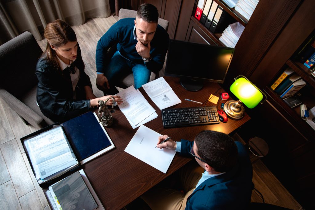 Couple going through lease agreement with their agent,lawyer in the office